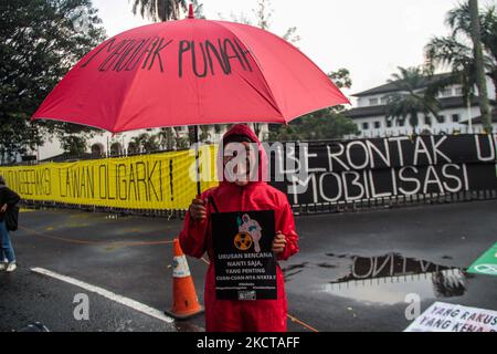 A man dressed as in the movie series 'Money Heist' holds a placard containing a protest about the climate crisis during action on November 5, 2021 in Bandung, West Java, Indonesia. Bandung BERISIK (United to Save the Climate) urges the Indonesian government to review and even stop all forms of development activities that damage the environment and contribute significantly to overcoming the climate crisis. (Photo by Algi Febri Sugita/NurPhoto) Stock Photo