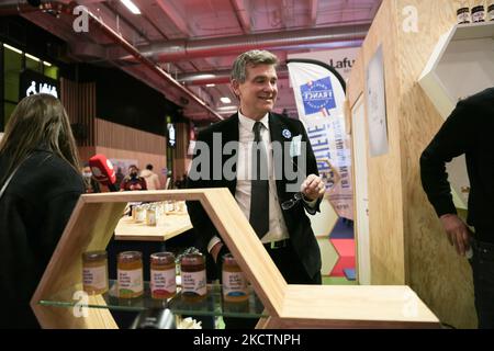 France's former PS (Socialist Party) Economy Minister and left-wing candidate for the 2022 French presidential election Arnaud Montebourg (C), is selling honey produced in France by his company, Bleu Blanc Ruche (bleu white hive) to visitors at the Made in France Fair, a show-window of French know-how at Porte de Versailles in Paris, on November 11, 2021. (Photo by Michel Stoupak/NurPhoto) Stock Photo