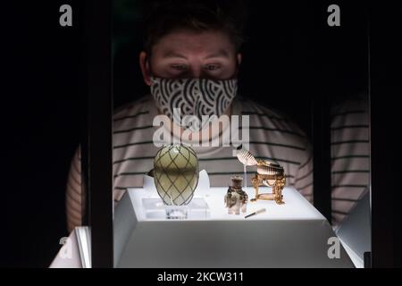 LONDON, UNITED KINGDOM - NOVEMBER 17, 2021: A staff member looks at the Diamond Trellis Egg (L) and the Third Imperial Easter Egg (R) during a photocall for the upcoming exhibition 'Faberge in London: Romance to Revolution' at the V&A (20 November 2021 – 8 May 2022), on 17 November, 2021 in London, England. The V&A’s major exhibition with over 200 objects on display including a collection of Imperial Easter Eggs will explore craftsmanship of master Russian goldsmith Carl Faberge and the Anglo-Russian nature of his enterprise. (Photo by WIktor Szymanowicz/NurPhoto) Stock Photo