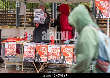 City of Westminster, London, UK. 5th Nov, 2022. The weather in London has been overcast and raining. Visitors are still out viewing the attractions. Preparations underway for a protest against the government. Person passing a socialist table advertising the general election now protest and promoting a general strike Stock Photo