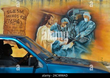 A man drives past a mural in the center of Merida, related to Covid-19 pandemic and painted to give recognition and appreciation to these 'heroes' who risk their lives to fight the virus. On Sunday, November 28, 2021, in Merida, Yucatan, Mexico. (Photo by Artur Widak/NurPhoto) Stock Photo