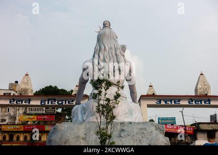 July 4th 2022 Haridwar India. Lord Shiva statue at the Haridwar railway Station with people sitting all around in waiting. Stock Photo