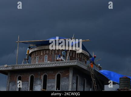 some of casual workers (construction workers) build a mosque dome in Tanjungrejo village, Malang, east java, on November 29, 2021. The Indonesian Ministry of Manpower encourages informal workers to register for BPJS Employment insurance at affordable rates. So that they get social protection in the form of Work Accident Insurance (JKK) protection. (Photo by Aman Rochman/NurPhoto) Stock Photo