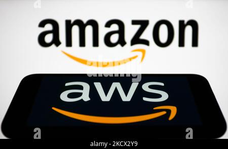 Amazon Web Services logo displayed on a phone screen and Amazon logo displayed on a laptop screen are seen in this illustration photo taken in Krakow, Poland on December 1, 2021. (Photo by Jakub Porzycki/NurPhoto) Stock Photo