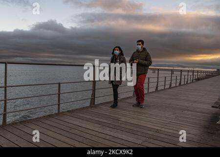 People wearing protective masks perform outdoor activities on the Tejo river promenade, near Vasco de Gama bridge, Lisbon. 04 December 2021. Portugal again recorded excess mortality due to Covid 19. November ended with 1,265 deaths more than the average for the years 2017 to 2019. A quarter of the deaths were caused by Covid. The Mortality Surveillance System, which analyses death certificates in real time, records an excess of deaths in the last 11 days. (Photo by Jorge Mantilla/NurPhoto) Stock Photo