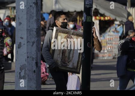 A pilgrim holds a picture of the Virgin of Guadalupe outside the Central de Autobuses del Norte in Mexico City during the COVID-19 health emergency in the capital. (Photo by Gerardo Vieyra/NurPhoto) Stock Photo