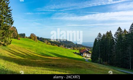 Ferienhaus, Hütte am Waldrand mit Aussicht über den Bregenzerwald mit Wiesen, Bäumen und Wälder. sonniger Herbst mit blauem Himmel und Schleierwolken Stock Photo
