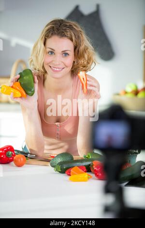 woman cooking salad for new vlog recording video in kitchen Stock Photo