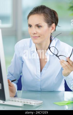 frustrated worried young woman looks at laptop Stock Photo