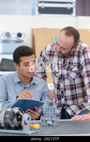 two male masters work in the workshop with electronics Stock Photo