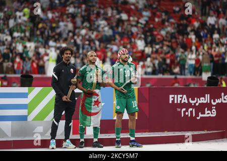 (11) Akram Afif of Qatar team, (11) Yacine Brahimi and (10) Mohammed Belaili of Algeria team pose with the Adidas Bronze Ball award, Adidas Gold Ball award and Adidas Silver Ball award following the FIFA Arab Cup Qatar 2021 Final match between Tunisia and Algeria at Al Bayt Stadium on December 18, 2021 in Al Khor, Qatar. (Photo by Ayman Aref/NurPhoto) Stock Photo