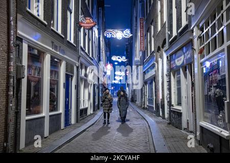 People as seen walking in front of the closed bars and restaurants. Streets of Amsterdam during the first day of the sudden lockdown in Dutch capital city. The first European nation declares a full lockdown to fight the new Omicron variant that surges, the Netherlands locks down after the government ordered the closure of all nonessential shops, cafes, restaurants, bars, gyms, schools, sports venues, cultural places and others from Sunday and for 4 weeks in order to prevent the spread of the Omicron mutation of Covid-19 coronavirus. Amsterdam, the Netherlands on December 19, 2021 (Photo by Nic Stock Photo