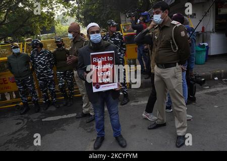 A demonstrator holds a placard as he stands in front of police personnel during a protest against hate speech event against Muslims at Uttarakhand's Haridwar, in New Delhi, India on December 27, 2021. (Photo by Mayank Makhija/NurPhoto) Stock Photo