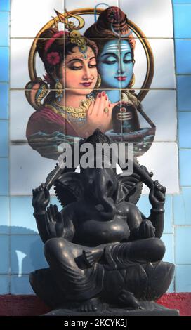 Idol of the Hindu God Lord Ganesha at the Hanuman Tok Mandir near the city of Gangtok in Sikkim, India. Behind are the images of Lord Shiva and his wife Parvati on a decorative tile. (Photo by Creative Touch Imaging Ltd./NurPhoto) Stock Photo