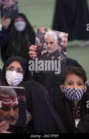 An Iranian young boy holds-up a portrait of former commander of the Islamic Revolutionary Guard Corps (IRGC) Quds Force, General Qasem Soleimani, during a ceremony to mark the second Soleimani death anniversary, in the Imam Khomeini Grand mosque in downtown Tehran on January 3, 2022. Iran marks the second death anniversary of the former commander of the Islamic Revolutionary Guard Corps (IRGC) Quds Force, General Qasem Soleimani, who has killed in a U.S. drone attack in Baghdad International Airport in Iraq. (Photo by Morteza Nikoubazl/NurPhoto) Stock Photo