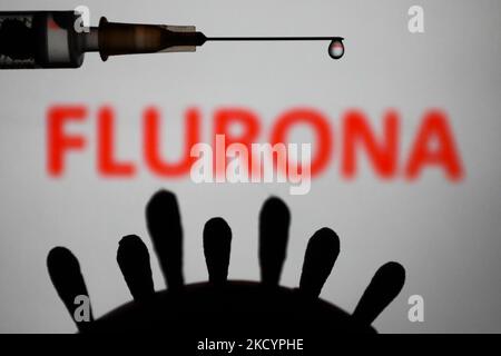 Coronavirus model, medical syringe and 'flurona' sign displayed in the background are seen in this illustration photo taken in Poland on January 4, 2022. Some countries reported cases of patients that were infected both COVID-19 and flu. (Photo by Jakub Porzycki/NurPhoto) Stock Photo