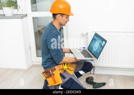 plumber at work. Installing water heating radiator Stock Photo