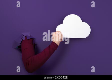Cloud computing concept, hand holding cloud over purple background, cloud storage Stock Photo