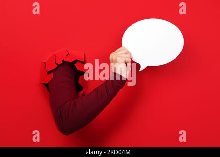 Talk bubble speech icon in hand over red background Stock Photo
