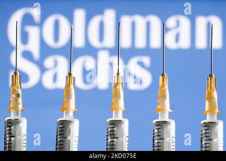 Medical syringes and Goldman Sachs logo displayed in the background are seen in this illustration photo taken in Krakow, Poland on January 11, 2022. (Photo by Jakub Porzycki/NurPhoto) Stock Photo