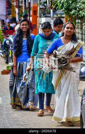 Hindu woman carries a bundle of dried coconut flower sheaths (kothumbu) to be used as fuel for a fire when cooking pongala during the Attukal Pongala Mahotsavam Festival in the city of Thiruvananthapuram (Trivandrum), Kerala, India, on February 19, 2019. The Attukal Pongala Mahotsavam Festival is celebrated by millions Hindu women each year. During this festival women prepare Pongala (rice cooked with jaggery, ghee, coconut and other ingredients) in the open in small pots to as an offering to Goddess Attukal Devi (popularly known as Attukal Amma) who is believed to fulfill the wishes of her de Stock Photo