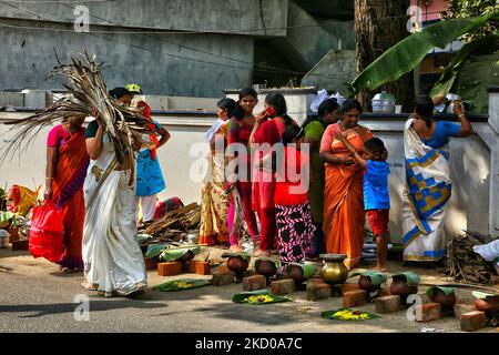 Hindu woman carries a bundle of dried coconut flower sheaths (kothumbu) to be used as fuel for a fire when cooking pongala during the Attukal Pongala Mahotsavam Festival in the city of Thiruvananthapuram (Trivandrum), Kerala, India, on February 19, 2019. The Attukal Pongala Mahotsavam Festival is celebrated by millions Hindu women each year. During this festival women prepare Pongala (rice cooked with jaggery, ghee, coconut and other ingredients) in the open in small pots to as an offering to Goddess Attukal Devi (popularly known as Attukal Amma) who is believed to fulfill the wishes of her de Stock Photo