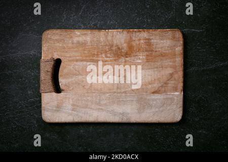 Empty cutting wood board on dark marble background, layout image Stock Photo