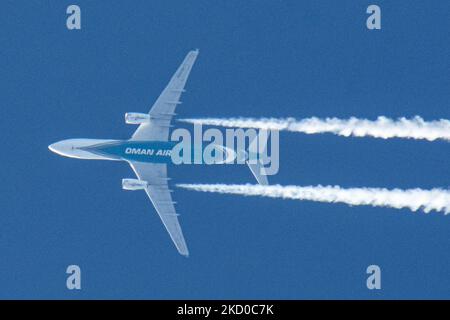 Oman Air Airbus A330 wide-body aircraft as seen flying at 40.000 feet of the Dutch city of Eindhoven during a clear blue sky day. The airline is the national carrier of the Sultanate of Oman a country on the southeastern coast of the Arabian Peninsula. The OMAN AIR logo inscription at the belly of the blue fuselage of the overfly plane is visible. The overflying airplane is traveling from the capital Muscat to London and leaves behind a white vapor condensation trail known as a contrail. The aviation industry and passenger traffic are phasing a difficult period with the Covid-19 coronavirus pa Stock Photo