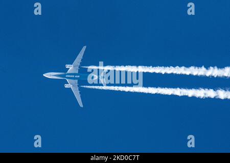 Oman Air Airbus A330 wide-body aircraft as seen flying at 40.000 feet of the Dutch city of Eindhoven during a clear blue sky day. The airline is the national carrier of the Sultanate of Oman a country on the southeastern coast of the Arabian Peninsula. The OMAN AIR logo inscription at the belly of the blue fuselage of the overfly plane is visible. The overflying airplane is traveling from the capital Muscat to London and leaves behind a white vapor condensation trail known as a contrail. The aviation industry and passenger traffic are phasing a difficult period with the Covid-19 coronavirus pa Stock Photo