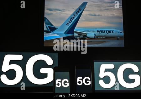 Images of the 5G sign displayed on the screens of mobile phones and computers in front of the Westjet planes displayed on the TV screen. On Tuesday, January 18, 2021, in Edmonton, Alberta, Canada. (Photo by Artur Widak/NurPhoto) Stock Photo