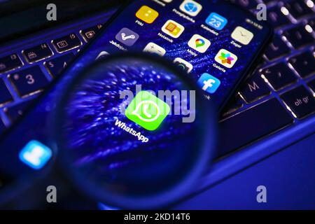 WHatsApp icon is seen through a magnifying glass while being displayed on a mobile phone screen for illustration photo. Gliwice, Poland on January 23, 2022. (Photo by Beata Zawrzel/NurPhoto) Stock Photo