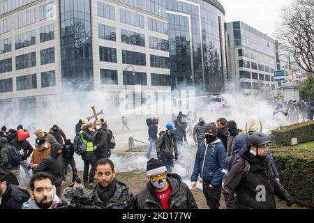 Demonstrators are sprayed from water cannons while clashing with police. Thousands Protest during the European Demonstration for Democracy against Covid-related measures like the COVID Health Pass And Restrictions. Riots started breaking out and police fire tear gas and water cannon as the protest turned violent. People take part in a demonstration against health measures in Brussels like the COVID Health Pass, the QR code, facemasks and the mandatory vaccination, using as a main slogan and on banners the word liberte translated as freedom. Authorities estimated that around 50,000 people from  Stock Photo