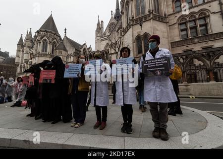 LONDON, UNITED KINGDOM - JANUARY 25, 2022: Protesters from Animal Rebellion, some dressed as plague doctors others as medical personnel, demonstrate outside the Royal Courts of Justice as campaigners from Humane Being launch a legal challenge today at the High Court against Department for Environment Food and Rural Affairs (Defra) in a bid to end factory farming in England on January 25, 2022 in London, England. In the world's first ever legal case against factory farming, the campaigners claim a ban on the practice is needed to prevent future pandemics and other threats to public health such  Stock Photo