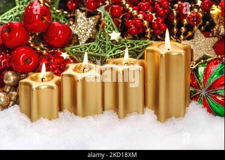 Four burning candles red ornaments Christmas advent decoration Stock Photo