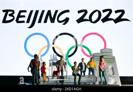 Illustration of a medical syringe, negative Covid-19 antigen tests, and figurines of athletes and spectators seen in front of the official Beijing 2022 Winter Olympic Games emblem displayed on a computer screen. On Thursday, January 27, 2022, San Cristobal de las Casas, Chiapas, Mexico. (Photo by Artur Widak/NurPhoto) Stock Photo