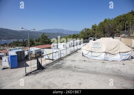 White tents in the official camp with the UNHCR - THE UN Refugee agency logo. The former official refugee - migrant camp surrounded by barbed wire fence at Vathy of Samos Island and the neighboring makeshift camp with handmade tents and some from UNHCR that is located just next to the houses of Vathi town, as seen deserted. The camp has been emptied and people relocated or moved with the police escort to the new camp and some very few houses. Once this facility hosted at its peak 7500 asylum seekers at the official facilities but also the makeshift camp in the forest that was nicknamed The Jun Stock Photo