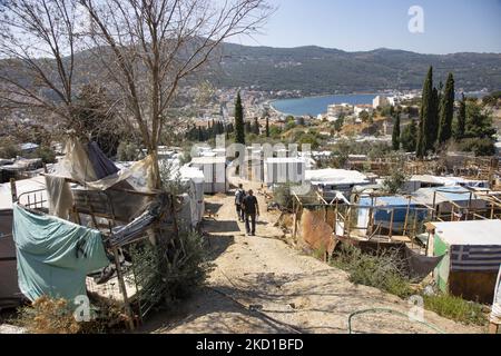 Panoramic view of the makeshift camp on the slobe with the town and port of Vathy visible. The former official refugee - migrant camp surrounded by barbed wire fence at Vathy of Samos Island and the neighboring makeshift camp with handmade tents and some from UNHCR that is located just next to the houses of Vathi town, as seen deserted. The camp has been emptied and people relocated or moved with the police escort to the new camp and some very few houses. Once this facility hosted at its peak 7500 asylum seekers at the official facilities but also the makeshift camp in the forest that was nick Stock Photo