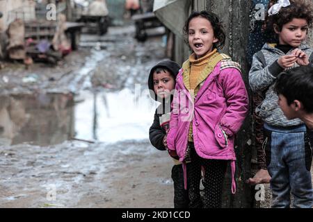 Palestinian children living in slums play in the street during cold weather in a slum in Gaza City, Thursday, January 27, 2022.(Photo by Momen Faiz/NurPhoto) Stock Photo