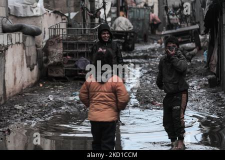 Palestinian children living in slums play in the street during cold weather in a slum in Gaza City, Thursday, January 27, 2022.(Photo by Momen Faiz/NurPhoto) Stock Photo