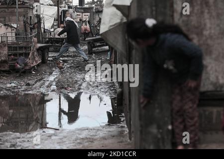 Palestinian children living in slums play in the street during cold weather in a slum in Gaza City, Thursday, January 27, 2022.(Photo by Momen Faiz/NurPhoto) Stock Photo