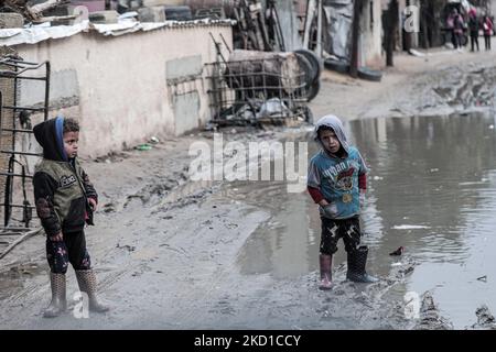 Palestinian children living in slums play in the street during cold weather in a slum in Gaza City, Thursday, January 27, 2022.(Photo by Momen Faiz/NurPhoto) Stock Photo