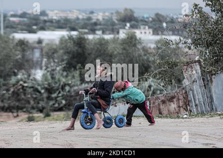 Palestinian children living in slums play in the street during cold weather in a slum in Gaza City, Thursday, January 27, 2022.(Photo by Momen Faiz/NurPhoto) Stock Photo