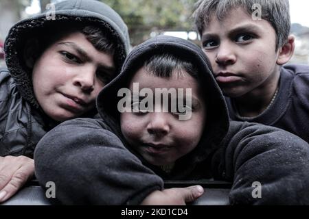 Palestinian children living in slums play in the street during cold weather in a slum in Gaza City, Thursday, January 27, 2022.(Photo by Momen Faiz/NurPhoto) Stock Photo