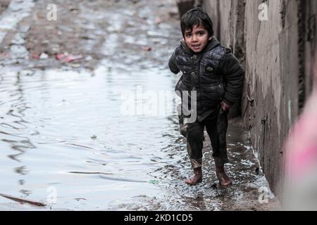 Palestinian children living in slums play in the street during cold weather in a slum in Gaza City, Thursday, January 27, 2022.(Photo by Momen Faiz/NurPhoto) Stock Photo