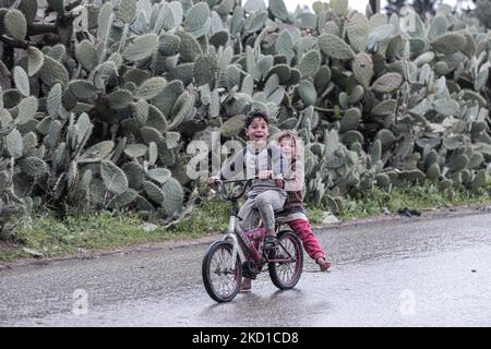 Palestinian children living in slums play in the street during cold weather in a slum in Gaza City, Thursday, January 27, 2022.(Photo by Momen Faiz/NurPhoto) Stock Photo