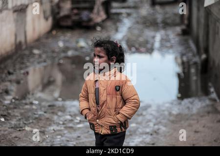 Palestinian children living in slums play in the street during cold weather in a slum in Gaza City, Thursday, January 27, 2022.(Photo by Momen Faiz/NurPhoto) Stock Photo