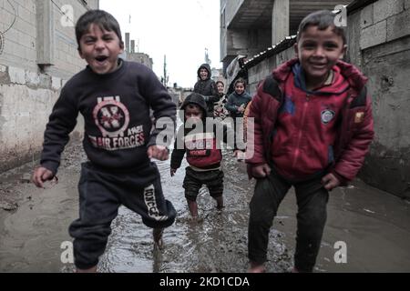 Palestinian children living in slums play in the street during cold weather in a slum in Gaza City, Thursday, January 27, 2022.(Photo by Momen Faiz/NurPhoto) Stock Photo