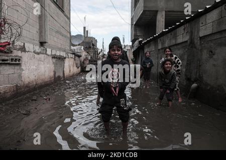 Palestinian children living in slums play in the street during cold weather in a slum in Gaza City, Thursday, January 27, 2022.(Photo by Momen Faiz/NurPhoto) Stock Photo