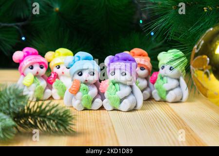 Handmade soap rabbits in bright hats with flower, symbol of 2023. Stock Photo