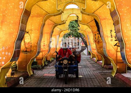 Workers ride through the Chinese New Year decorations at the Fo Guang Shan Dong Zen Temple ahead of the upcoming Lunar New Year of the Tiger on January 28, 2022 in Jenjarom outside Kuala Lumpur, Malaysia. (Photo by Mohd Firdaus/NurPhoto) Stock Photo